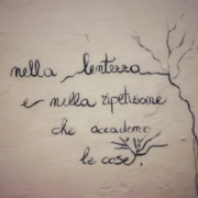 Una scritta a mano su un muro: «È nella lentezza e nella ripetizione che accadono le cose»