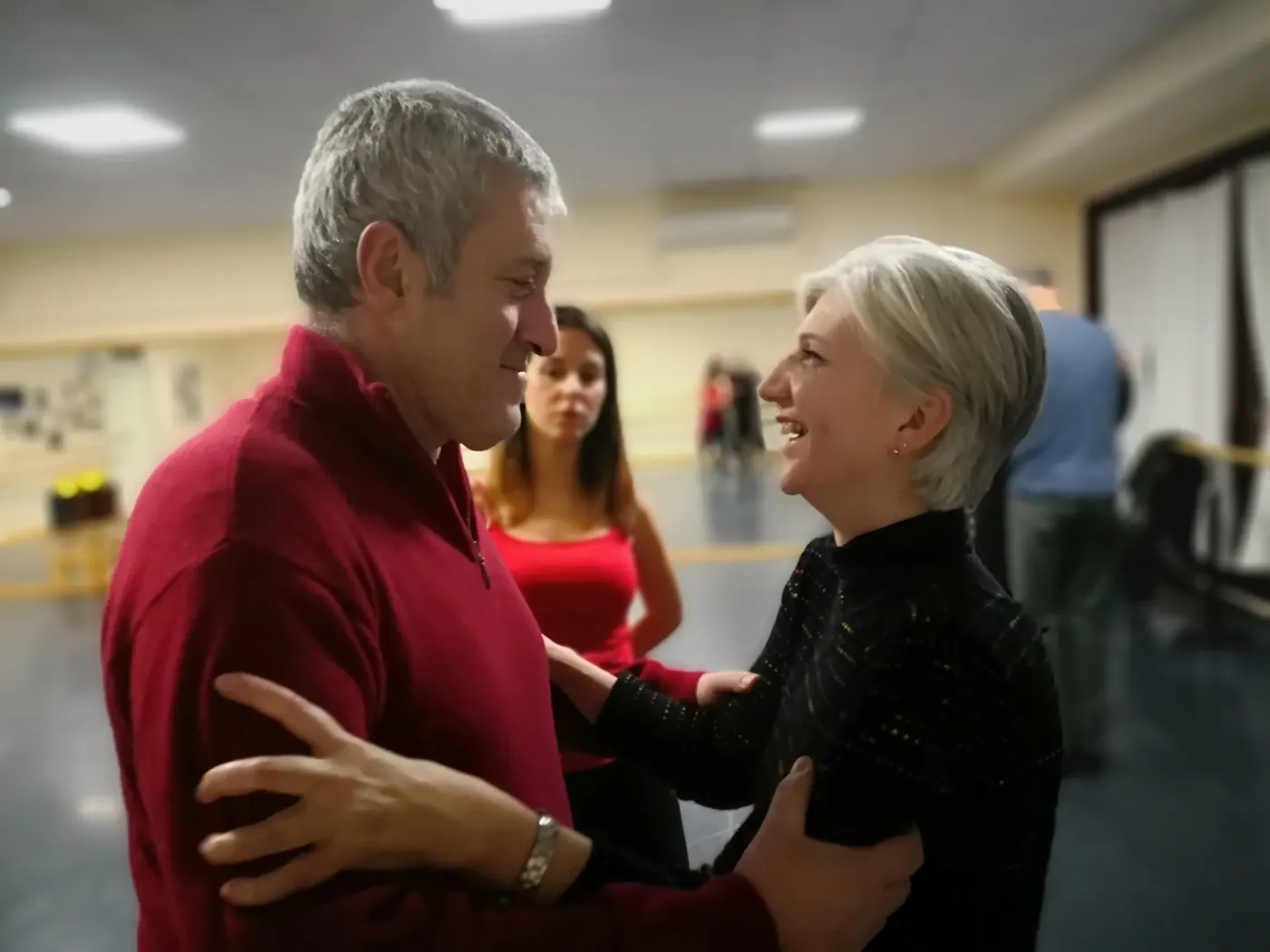 Due allievi si abbracciano sorridendo durante una pratica di tango argentino